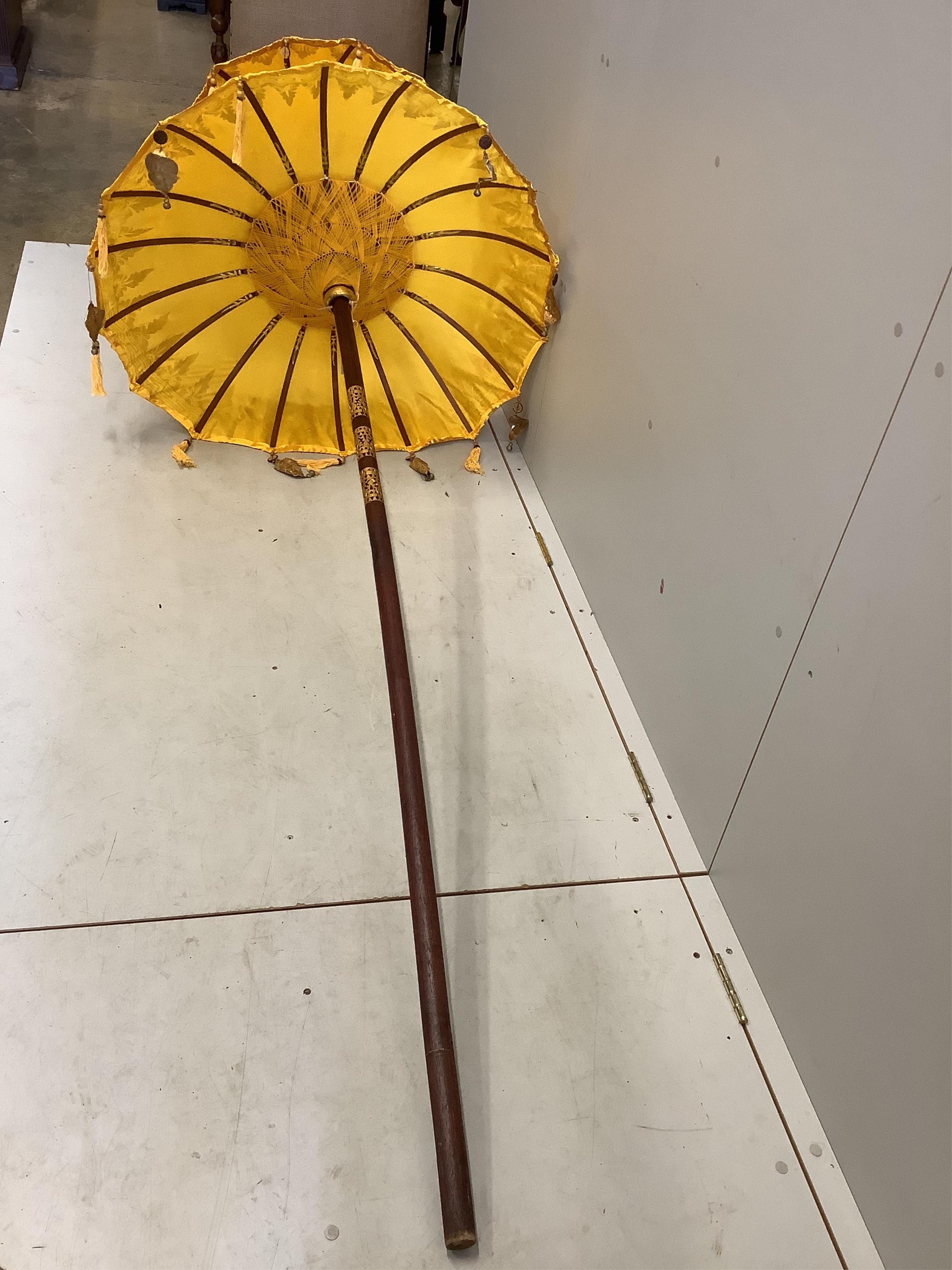 Two Indian parasols, larger approximately height 250cm. Condition - fair